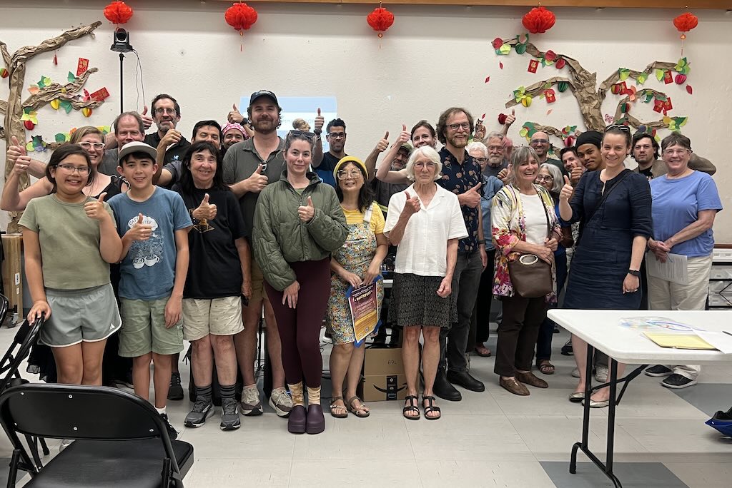 Community members at the Safe Streets Bernal meeting at the Bernal Heights Neighborhood Center giving a thumbs up in support of light green daylighting on Cortland Street